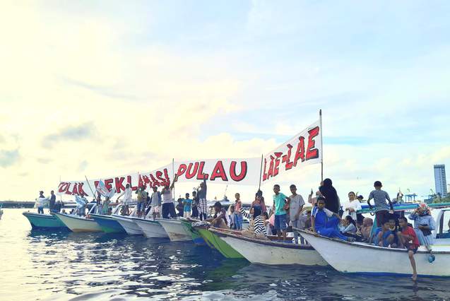 Warga menggelar unjuk rasa dengan membentangkan spanduk menggunakan perahu,  menolak rencana reklamasi. FOTO: Ist