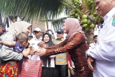 Bupati Nunukan Hj Asmin Lauyra Hafid menyerahkan bingkisan kepada warga di perbatasan negara saat meresmikan dimulainya pemanfaatan air bersih PDAM di Desa Ajikuning. FOTO: FB Pemkab Nunukan 